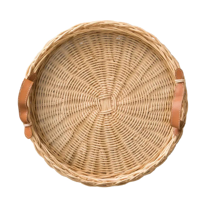Woven basket with leather handles on a gray surface