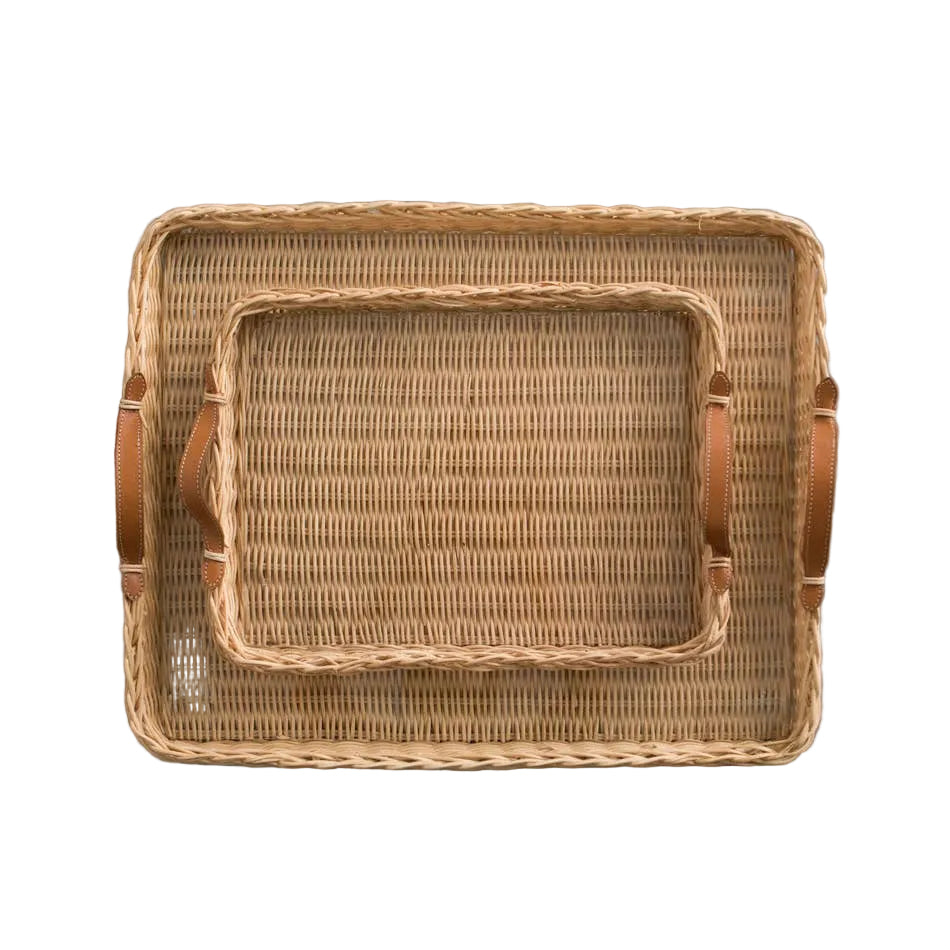Woven rattan tray with leather handles on a gray background