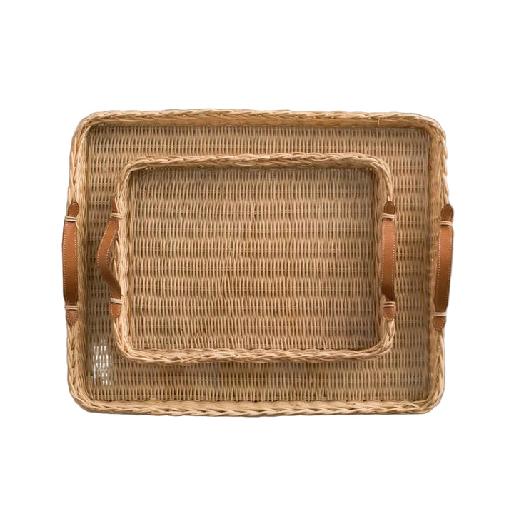 Woven rattan tray with leather handles on a gray background