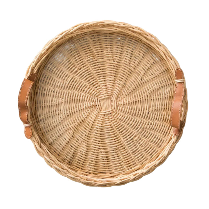 Woven basket with leather handles on a gray surface