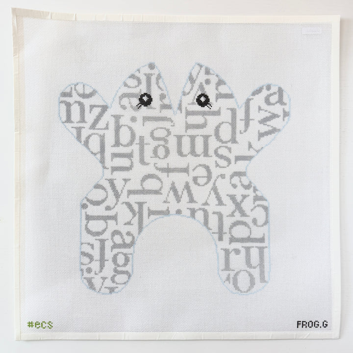needlepoint pattern of a frog made from letters on a white mesh background