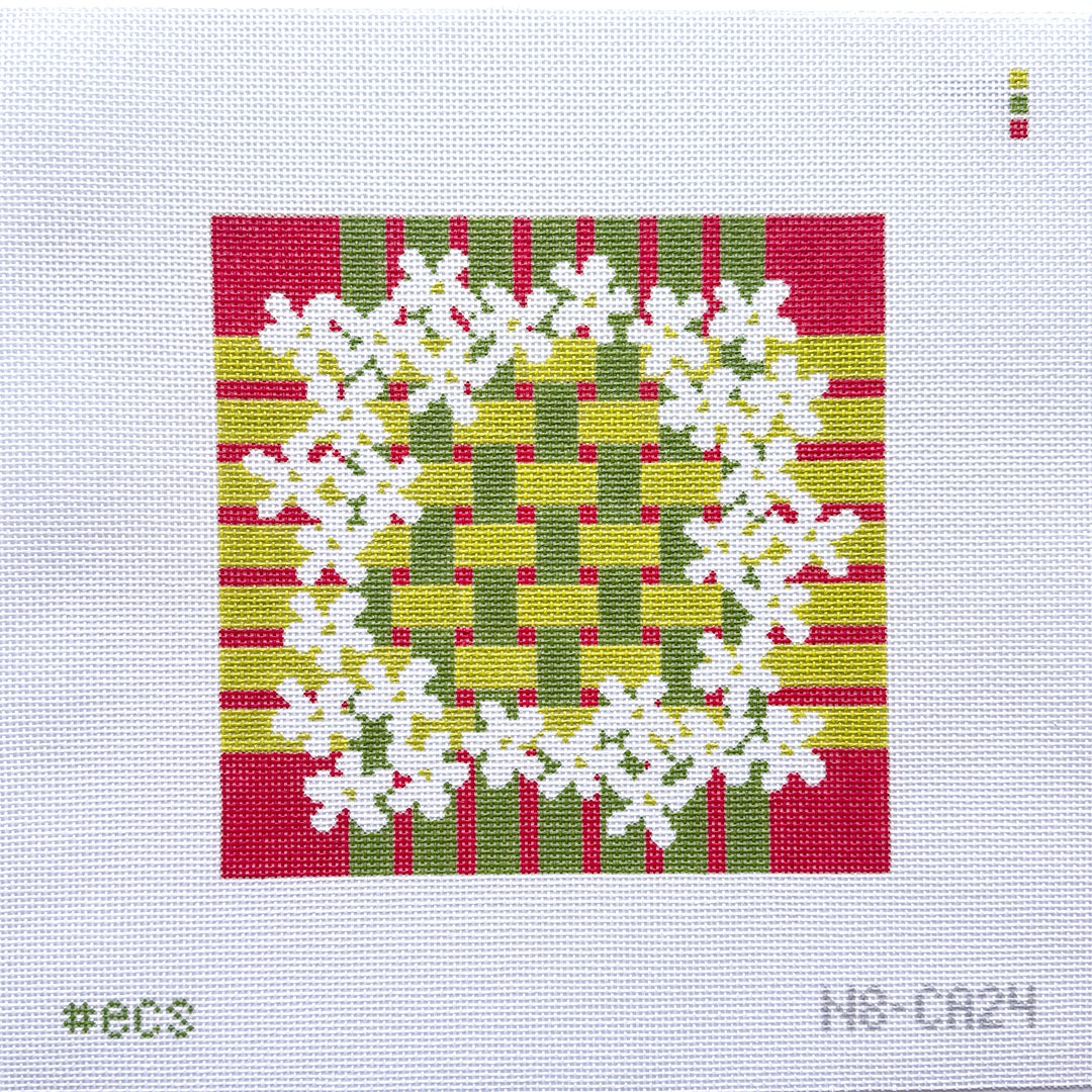 Square needlepoint with white floral design on a red, green, and yellow striped background
